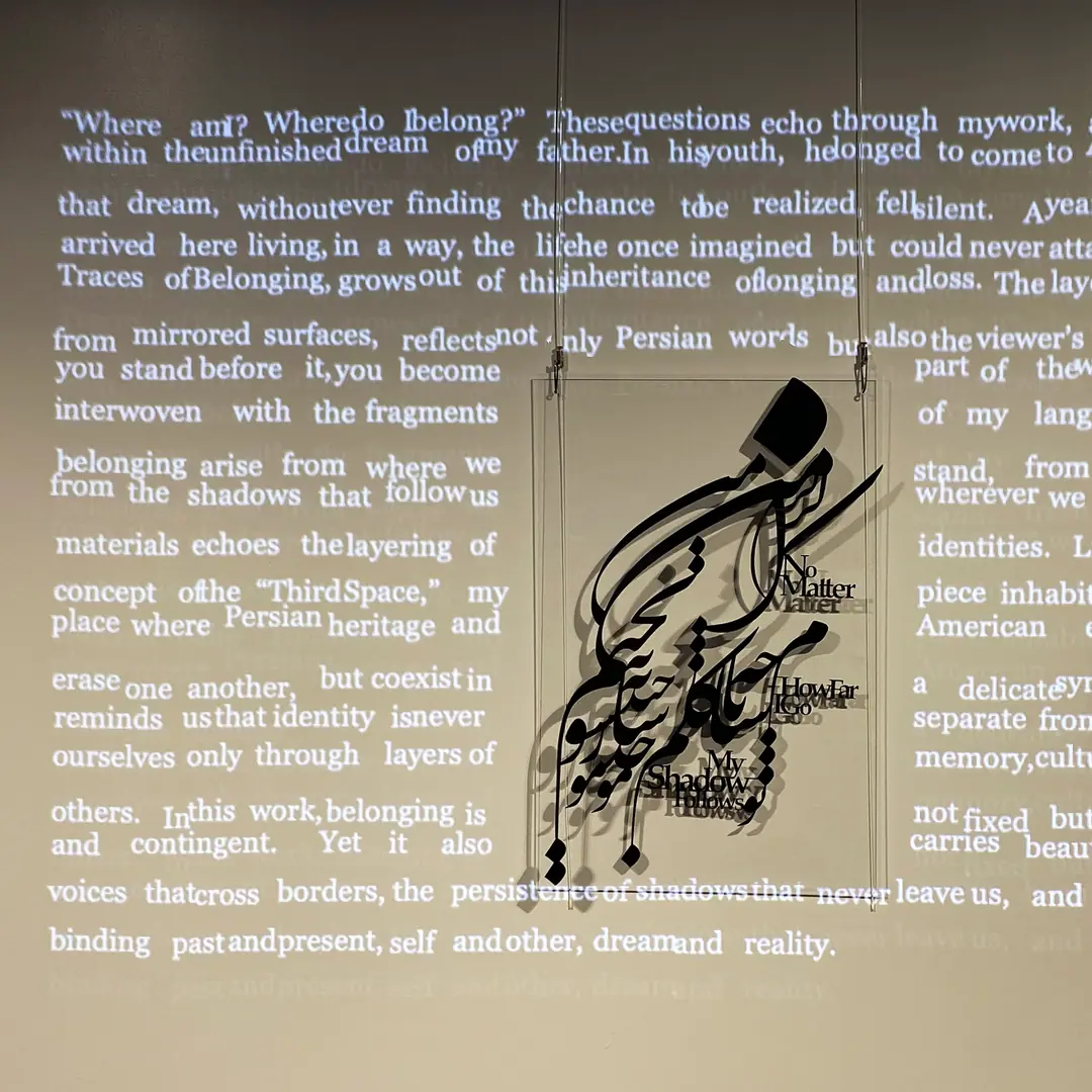 Black cut Persian calligraphy suspended in front of a wall of projected English text
