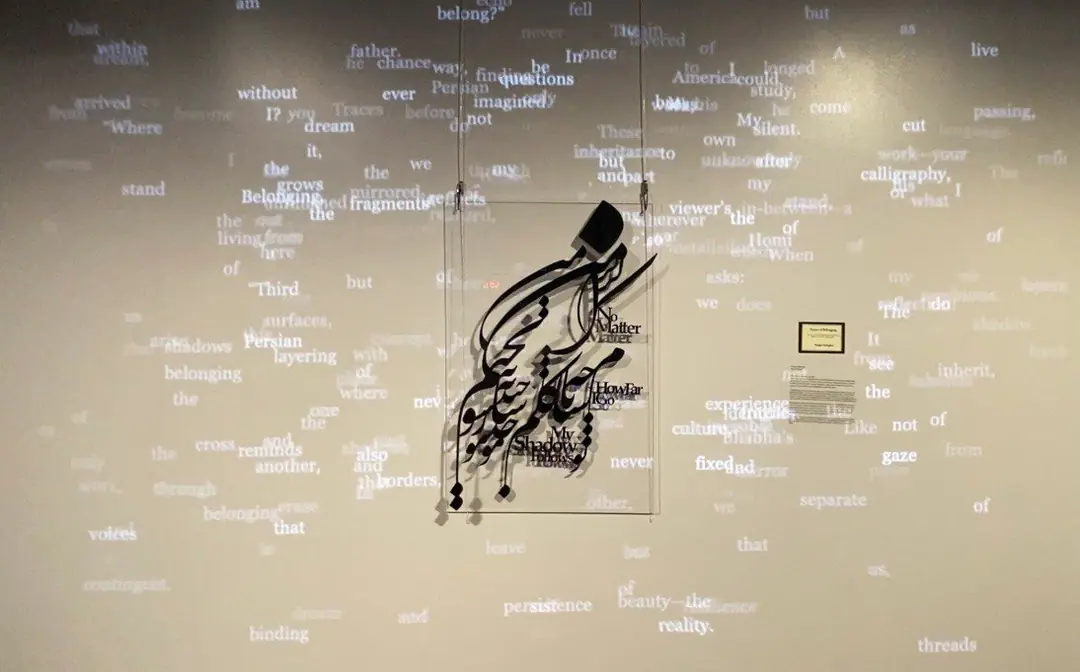 Scattered projected words drift around the suspended calligraphy
