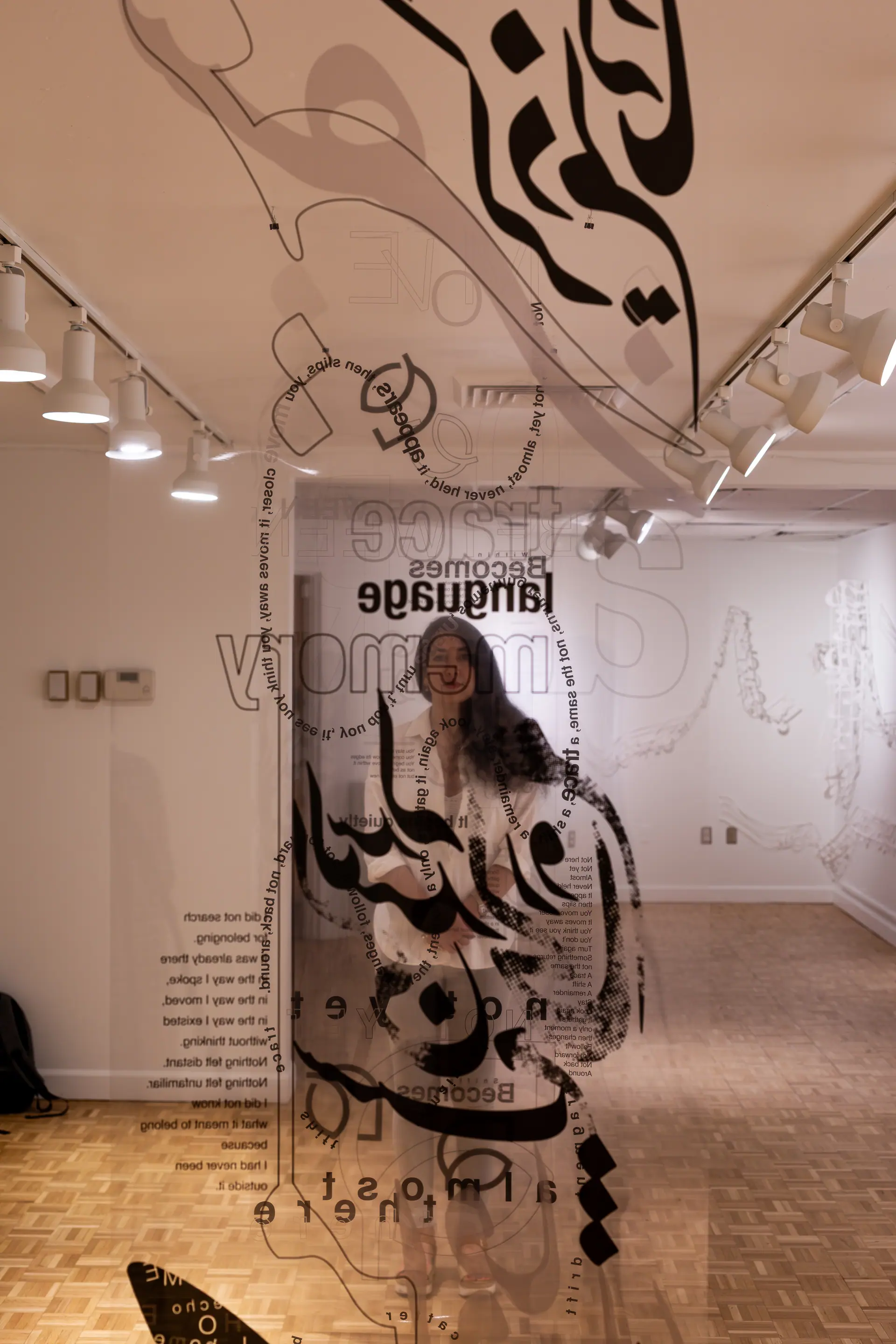 The artist seen through layered transparent panels of Persian calligraphy and English words